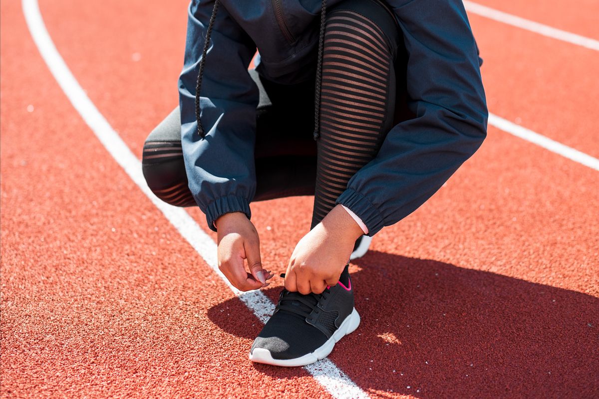 Running shoes resting on a red track lane